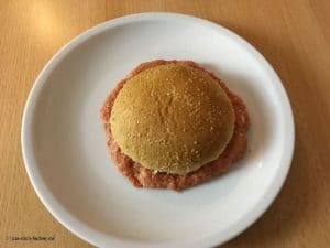 Ein Burger Pattie auf einem Teller.