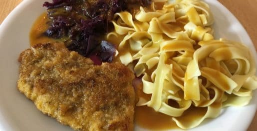 Panierte Schnitzel mit Bandnudeln, Rotkohl und Rahmsoße