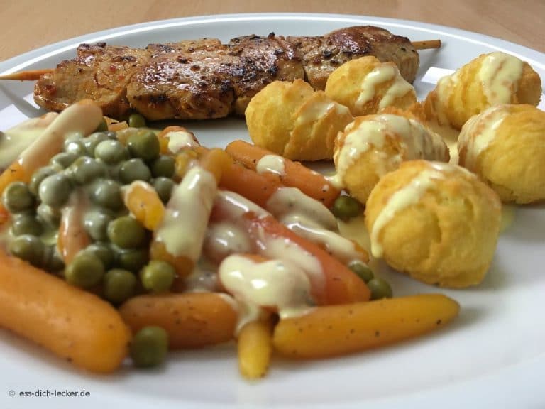 Schweinefiletspieße mit Kroketten, Erbsen und Möhren und Sauce ...